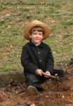 An Amish boy playing with a hammer