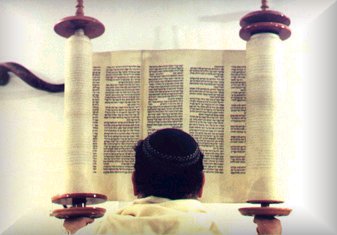 A rabbi reading a large scroll