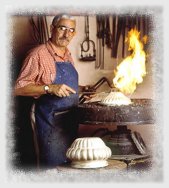 Silver smith putting heat to a silver bowl